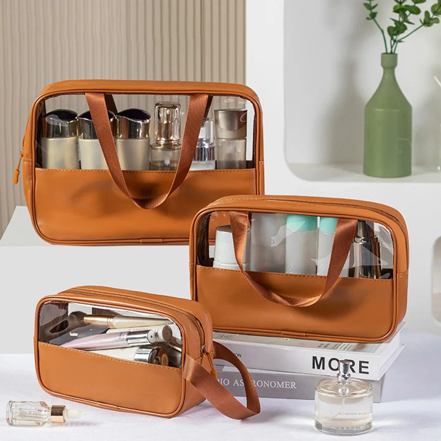 Set of three brown matte translucent toiletry bags filled with makeup and skincare products, displayed on a vanity with books and decor items